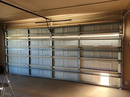 A garage door is open and the sun is shining through it.