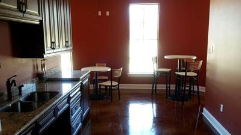 The inside of a church with rows of wooden benches and stained glass windows.