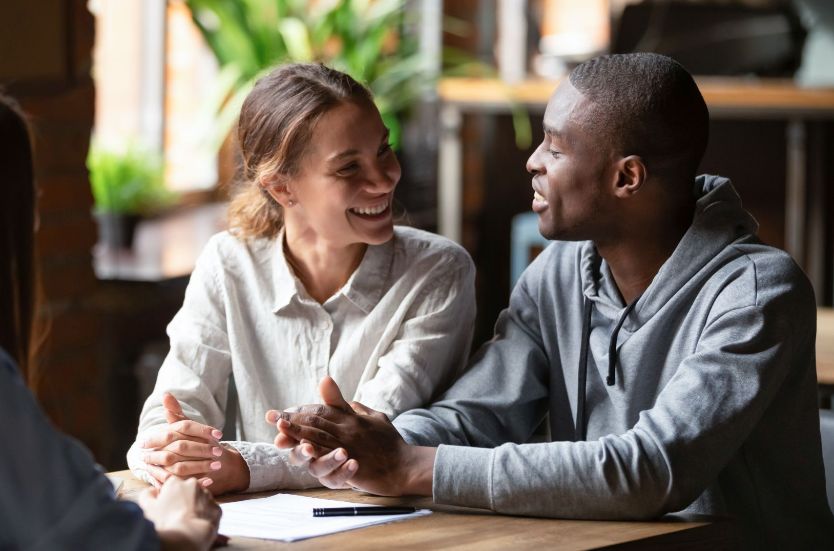 An elderly couple hugging each other on a rooftop at sunset.