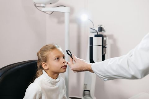 A young girl is getting her eyes checked.