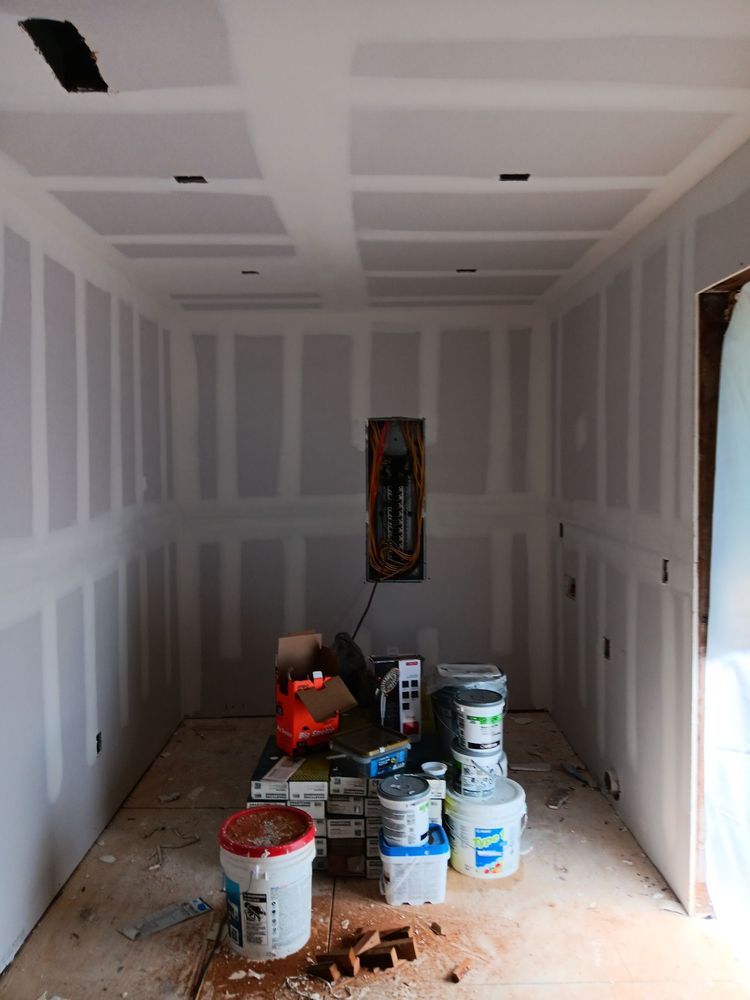A room with a lot of buckets of paint on the floor