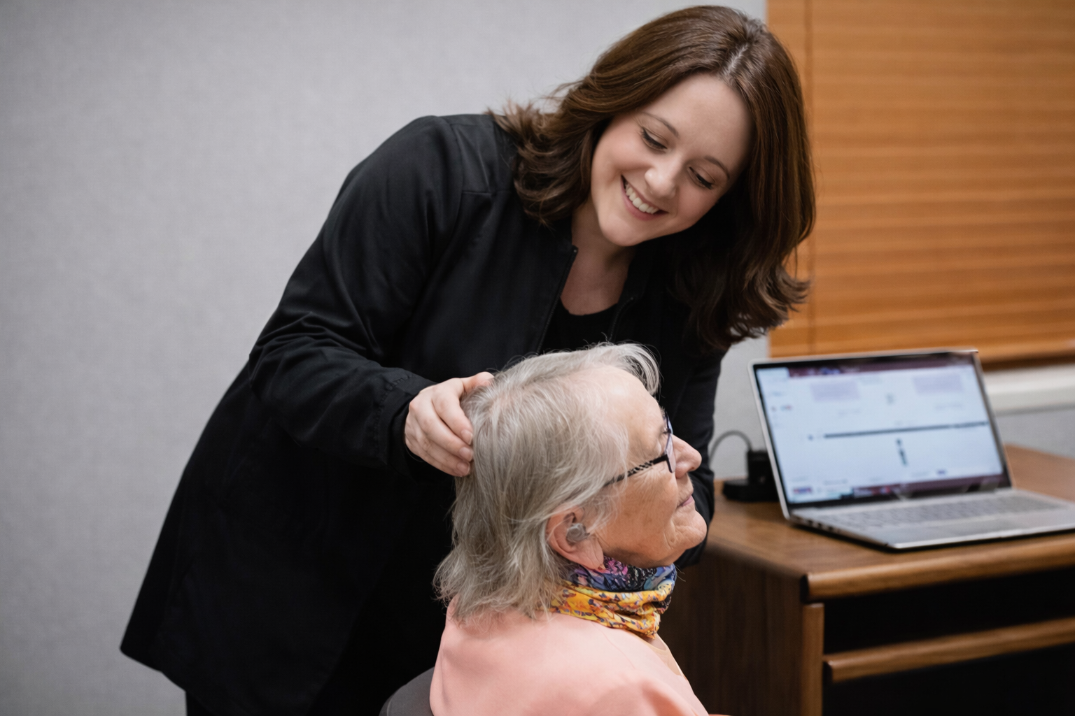 A certified audiologist performing an ear examination with an otoscope in a medical clinic. A certified audiologist performing an ear examination with an otoscope in a medical clinic.