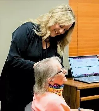 A certified audiologist performing an ear examination with an otoscope in a medical clinic. A certified audiologist performing an ear examination with an otoscope in a medical clinic.