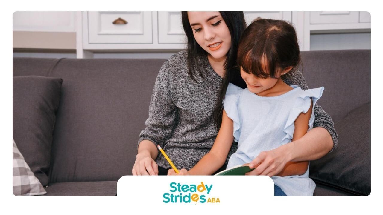 A BCBA and a little girl are sitting on a couch in ABA therapy.