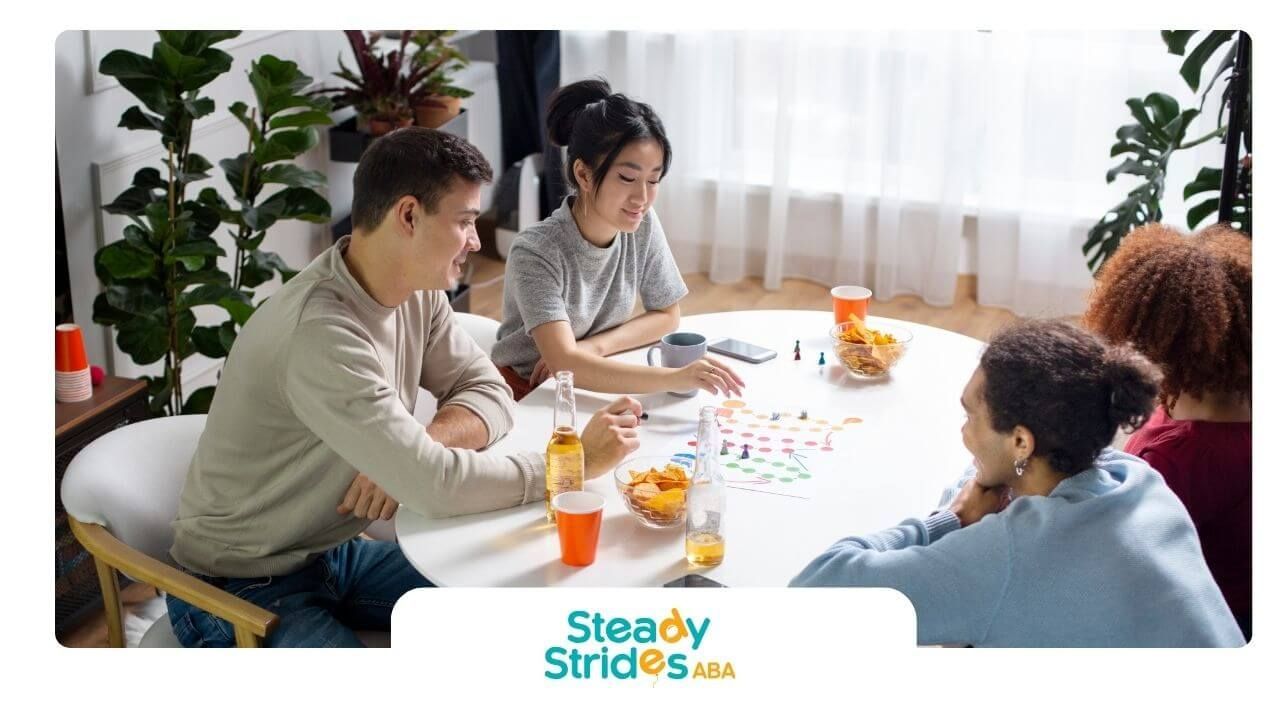 Group of therapists sitting around a table playing a board game and talking together at home.