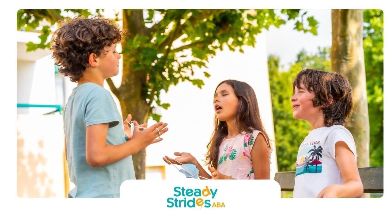 Three autistic stand outdoors in front of trees, having a conversation and enjoying the moment.