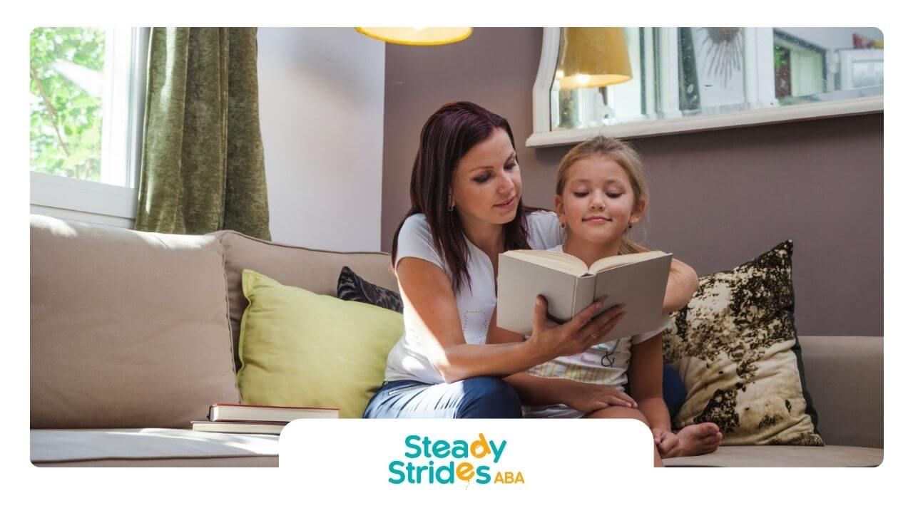 BCBA reading a book to a young girl with autism on a couch at home.