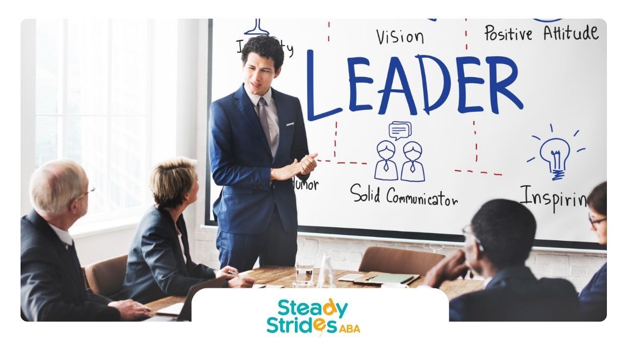 An autistic man in a suit and tie is standing in front of a whiteboard.