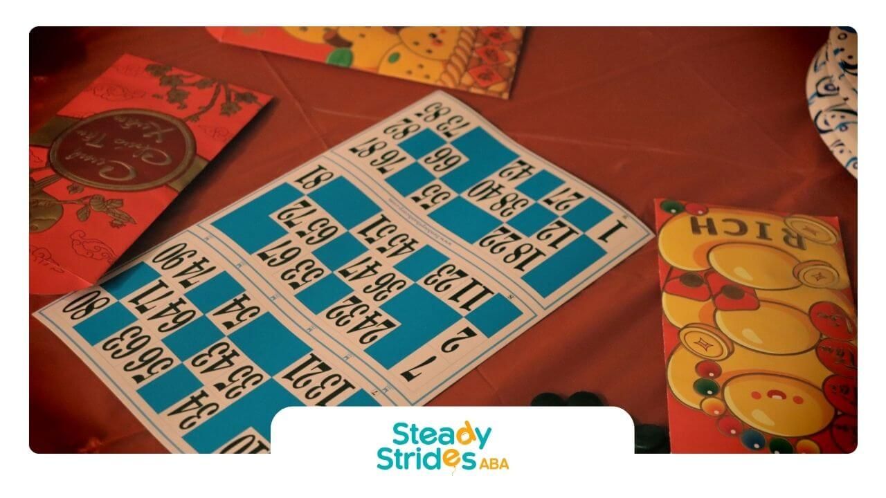 Festive bingo setup with upside-down card, tokens, and colorful envelopes on red tablecloth