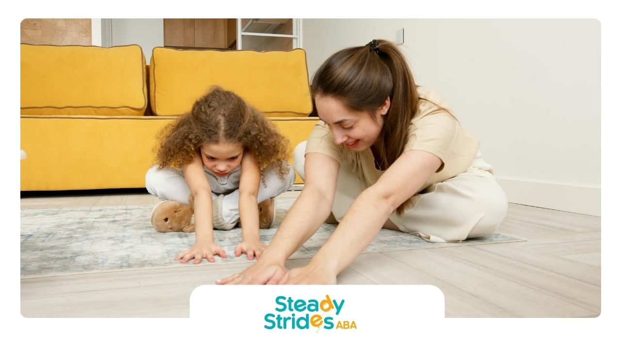 An ABA therapist and autistic child stretching together on a living room during ABA therapy in TX.