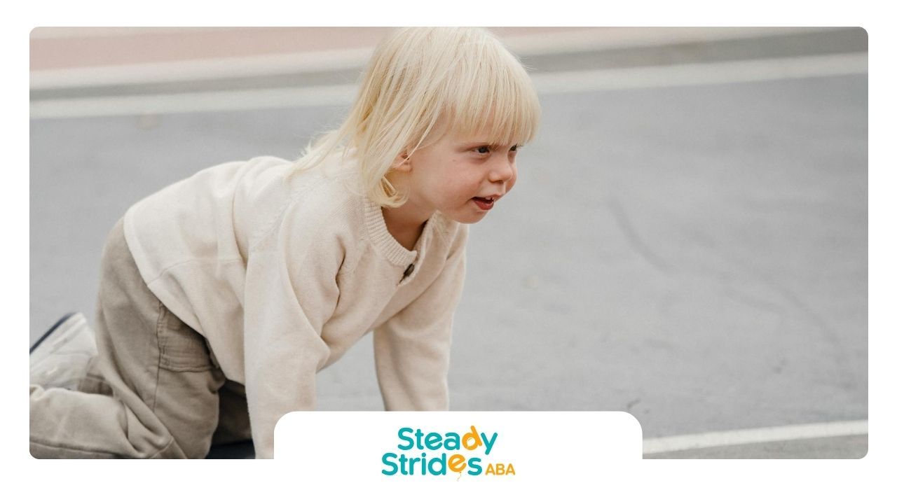 Blond child with autism crawling on a playground in Texas, showing autistic shutdown signs.