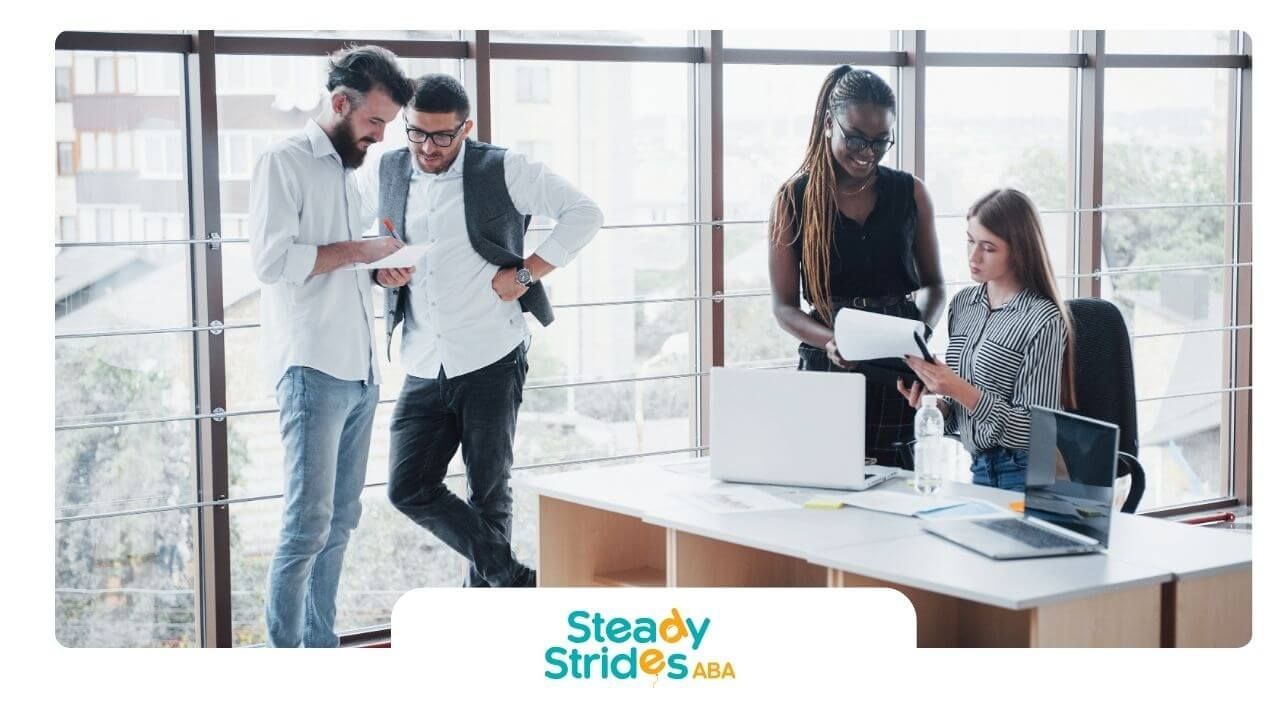 Group of therapists reviewing paperwork together in a bright office setting during a meeting.