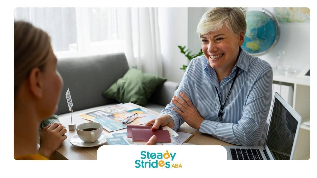 ABA therapist hands informational cards to a parent during a consultation about child development.