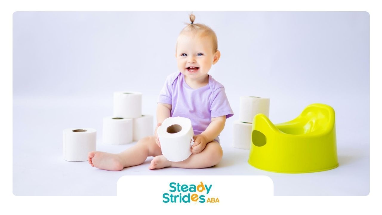 A baby is sitting on a potty holding a roll of toilet paper.