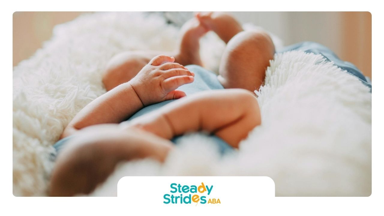 Close-up of an autistic baby lying on soft white blanket during autism evaluation at a clinic in TX.