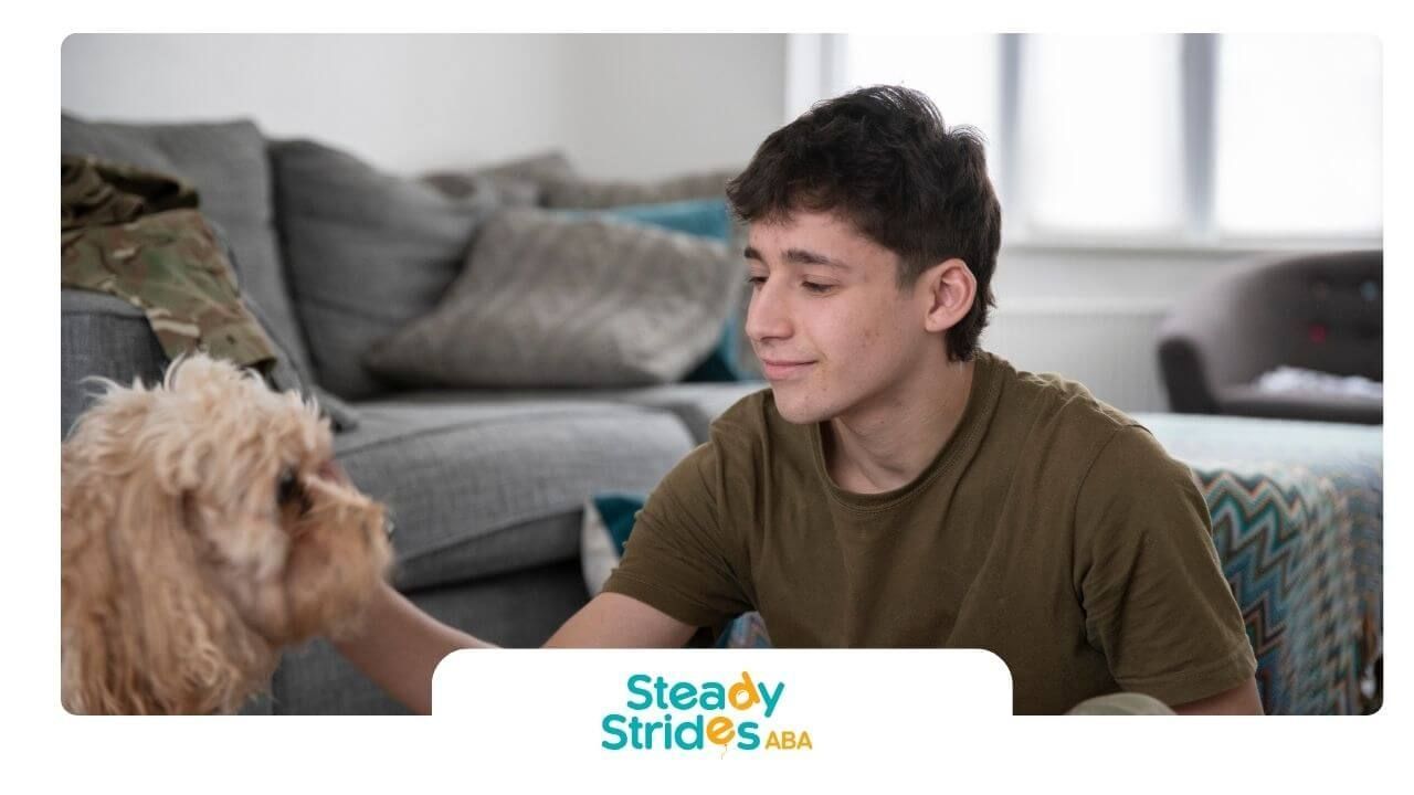 Autistic teen sitting on the floor at home gently petting a small dog in a calm, comfortable place.