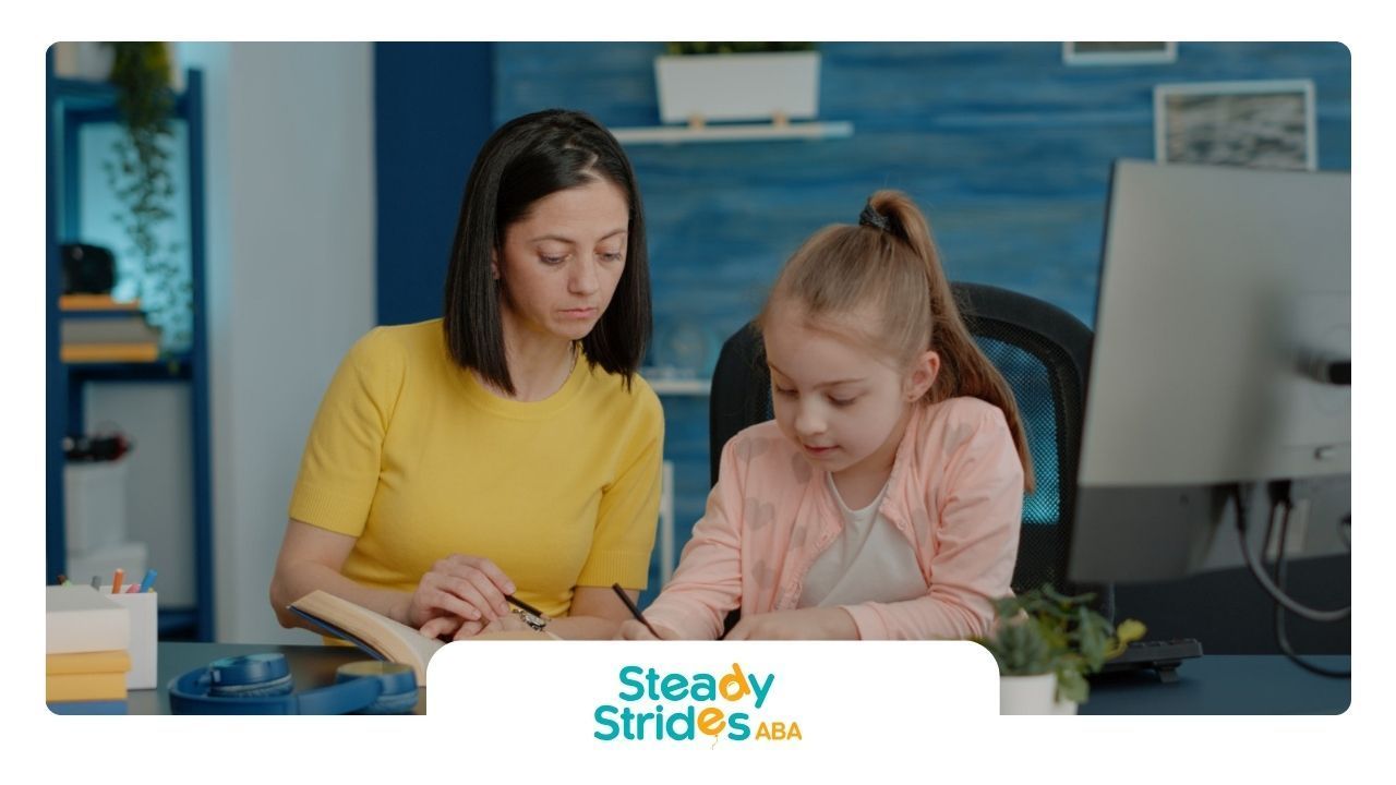 An ABA therapist is helping a little girl with her homework.