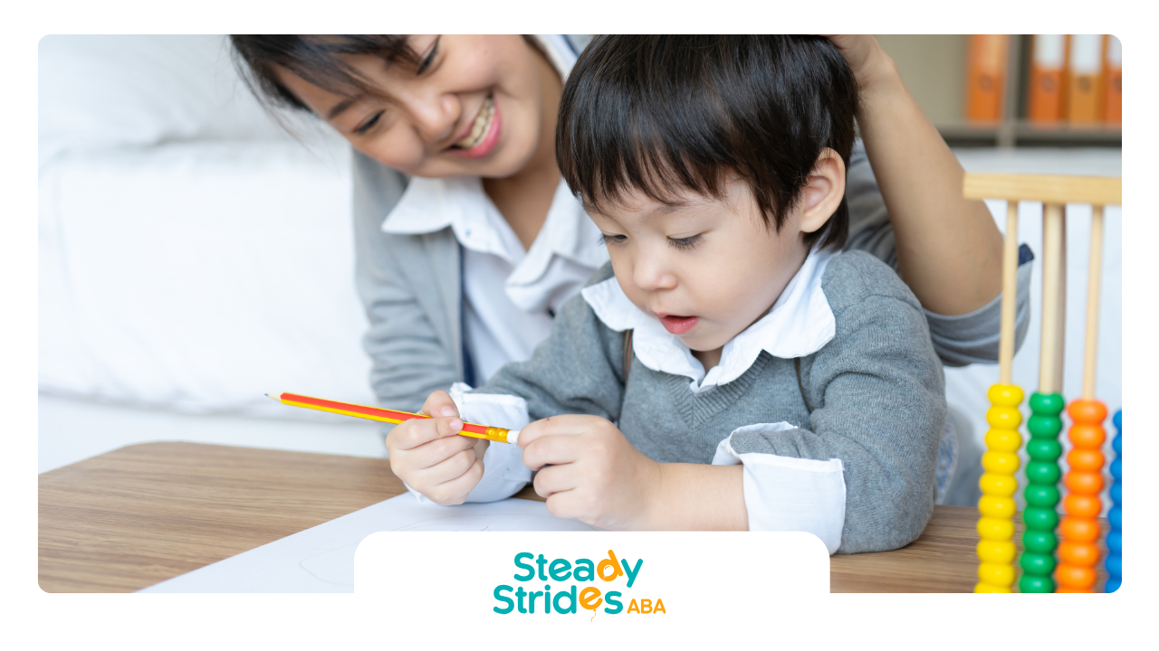 A woman is helping a young boy with a pencil