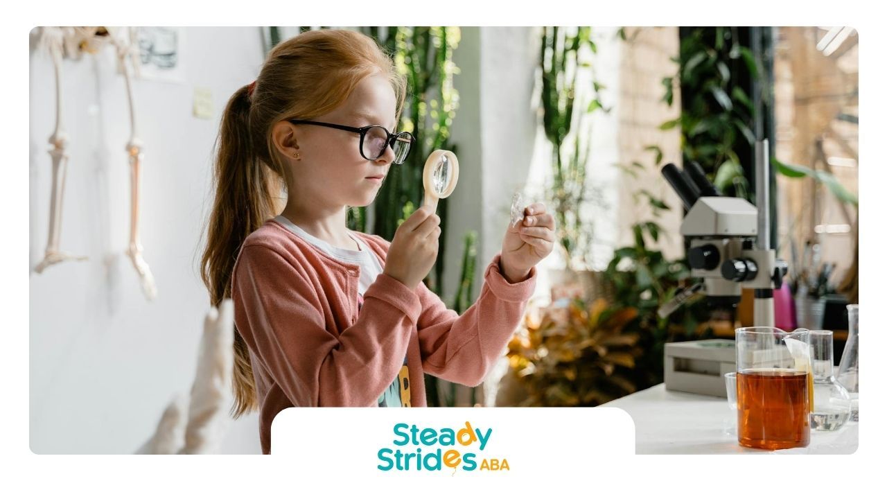 An autistic girl using a magnifying glass during ABA therapy at a science classroom in Texas.