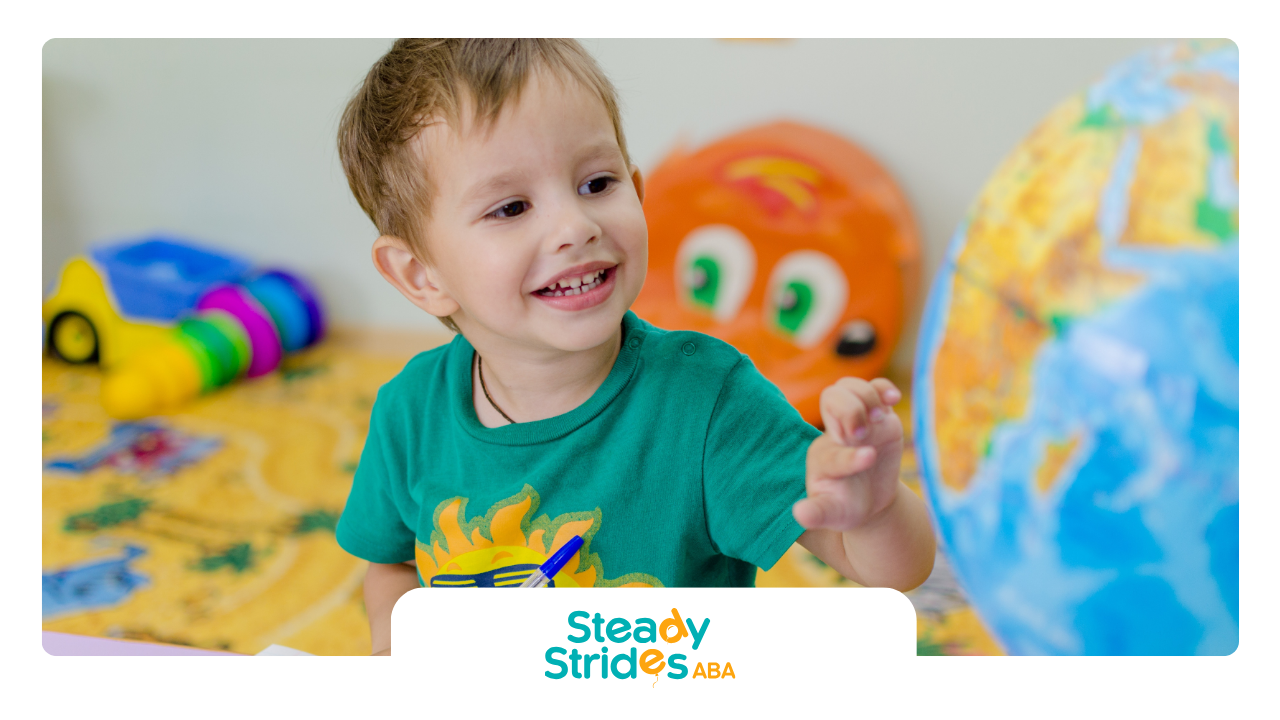 Smiling child reaching, toys and globe in background.