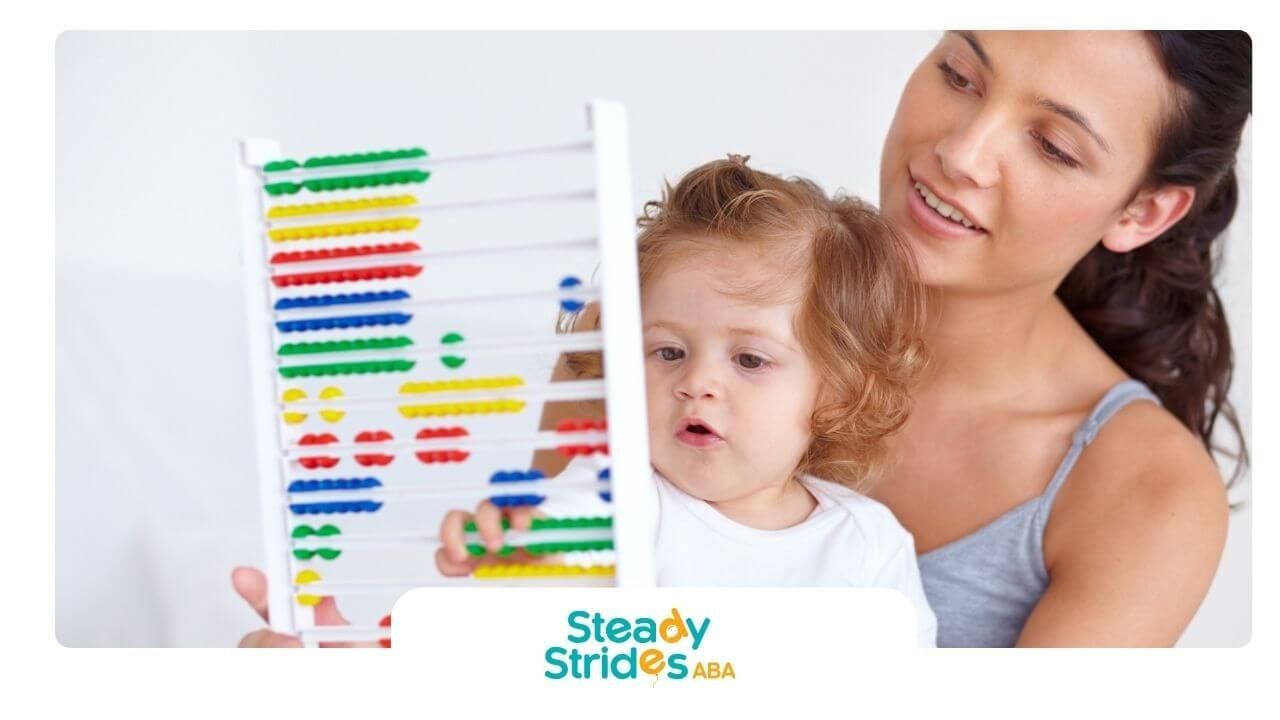Therapist helps autistic child use colorful abacus to build early learning, focus, and motor skills.