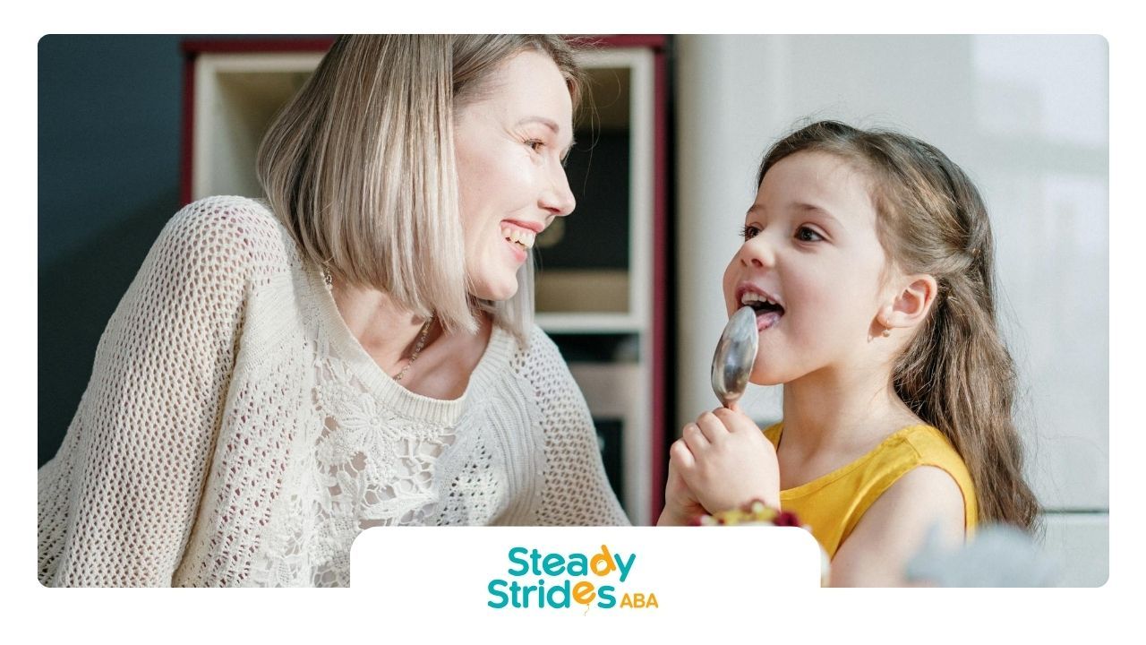 A mother watching her young autistic daughter lick icing from a spoon after ABA therapy in Texas.
