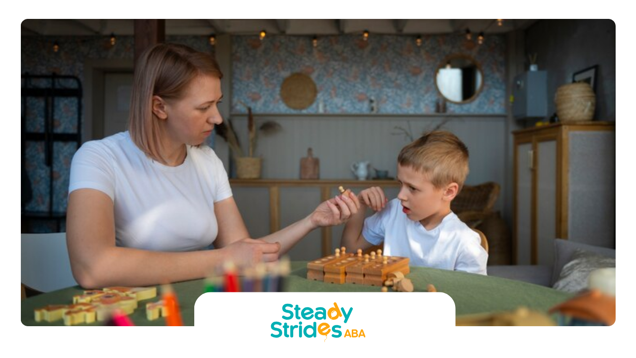 An RBT and a boy are playing a game at a table during their ABA therapy session