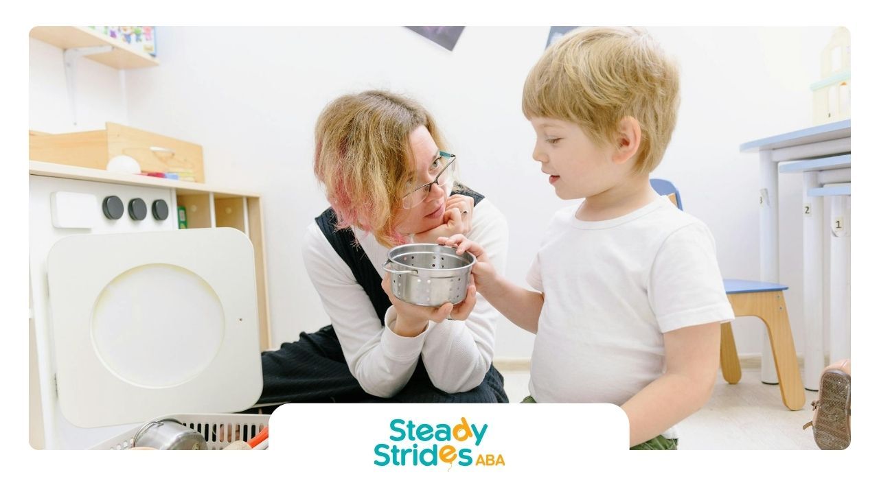 An RBT shows a toy pot to an autistic child during a center-based ABA therapy program in New Mexico.