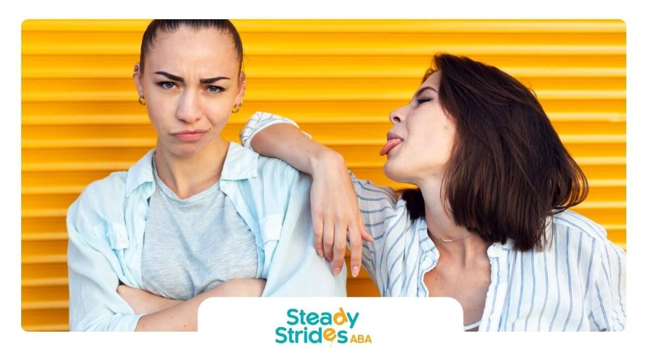 One woman with autism looks annoyed while another sticks out her tongue.