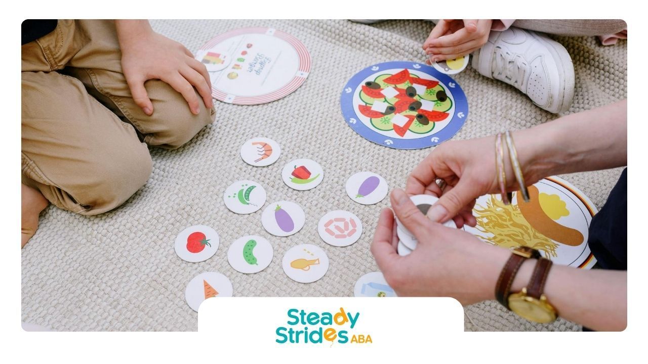 Autistic children playing an matching card game on the floor during school-based ABA therapy in TX.