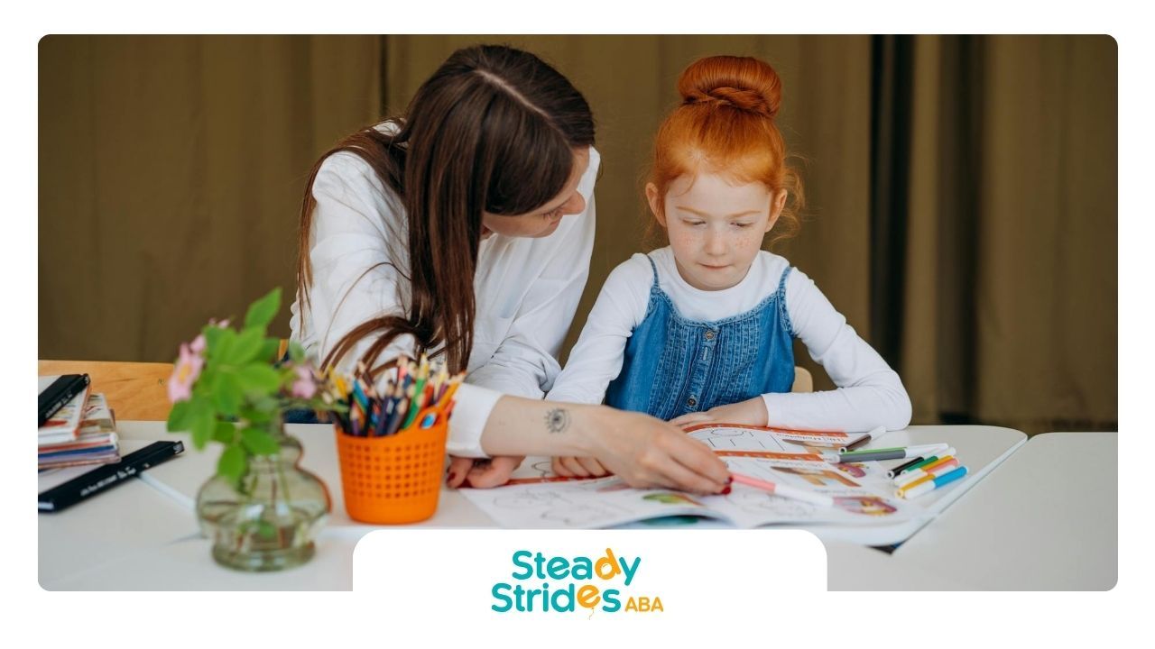 An ABA therapist helping a red-haired autistic girl with homework during ABA therapy session in TX.