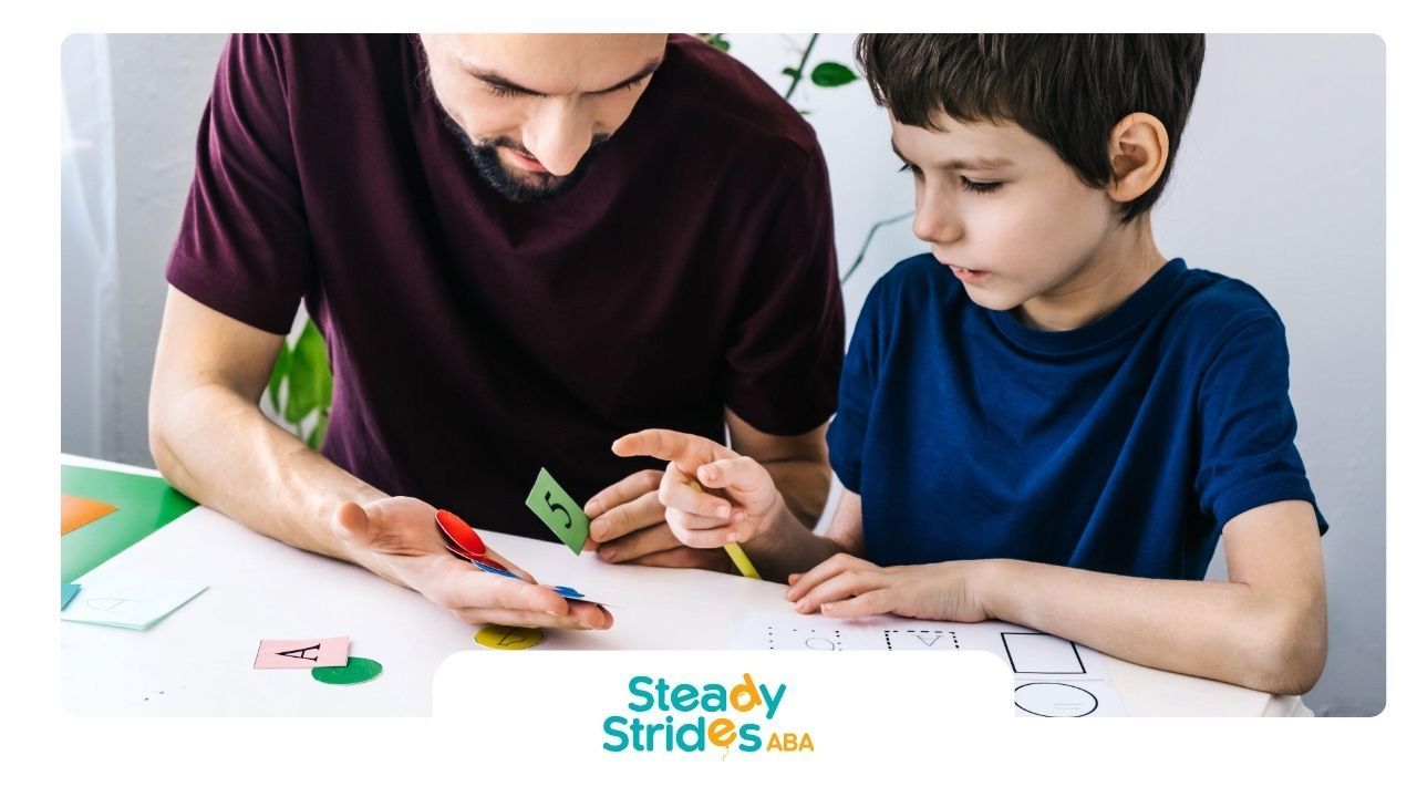 Person helps a child trace shapes on a paper, teaching concepts with colored cutouts.