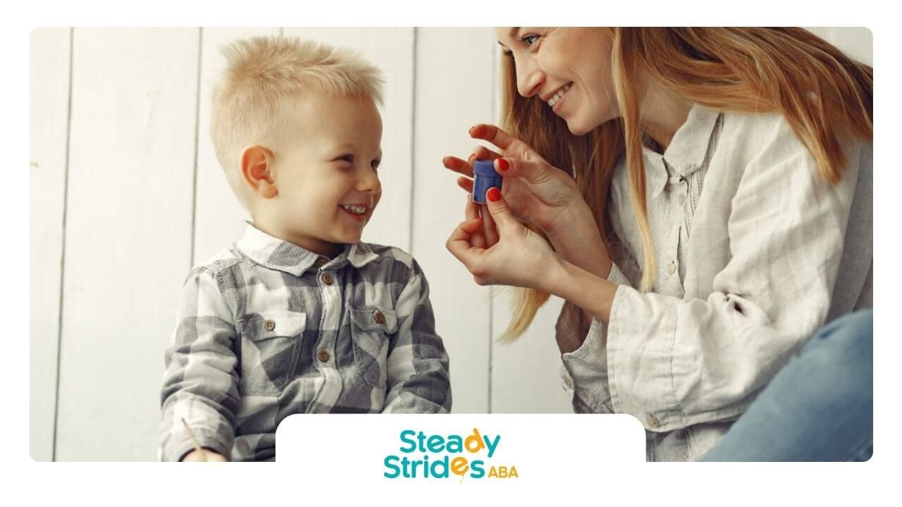 A BCBA and a child are playing with a toy in ABA therapy.