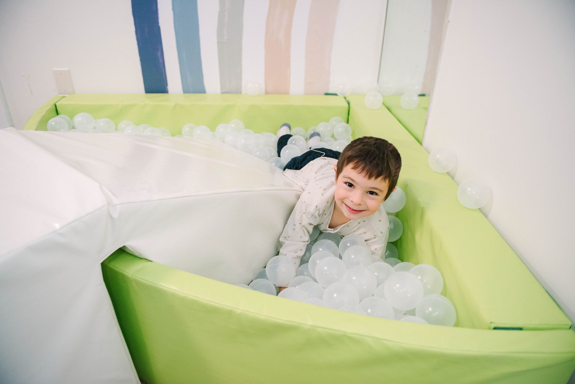 A boy playing in a ball pit at Steady Strides ABA therapy room