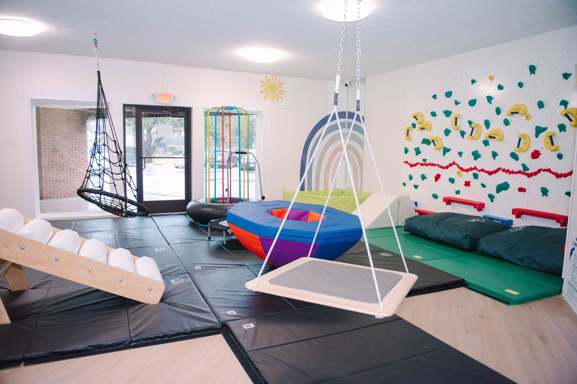 A large room filled with lots of toys and a climbing wall.