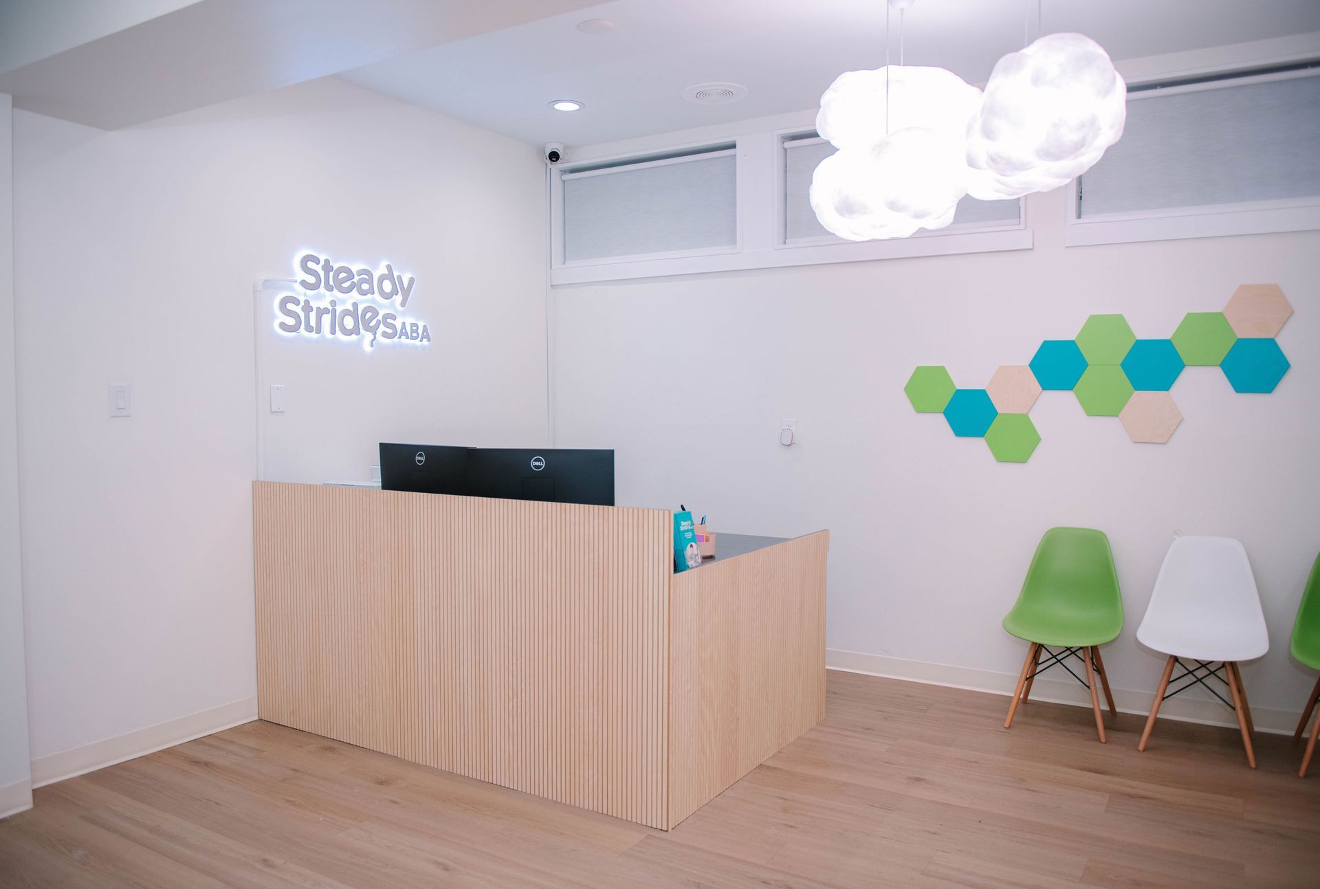 A waiting room with a wooden reception desk and chairs.