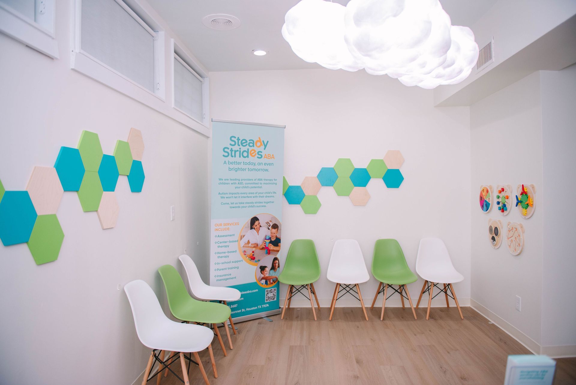 A waiting room with chairs and a sign on the wall.