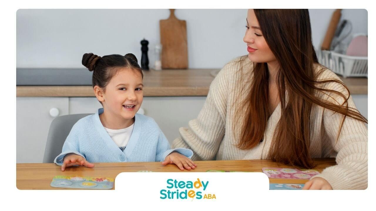 Therapist and autistic girl playing matching card game at table, supporting learning during therapy