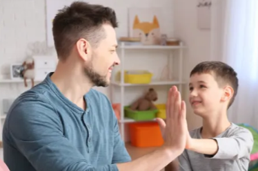A person teaching a child how to write with a green pencil