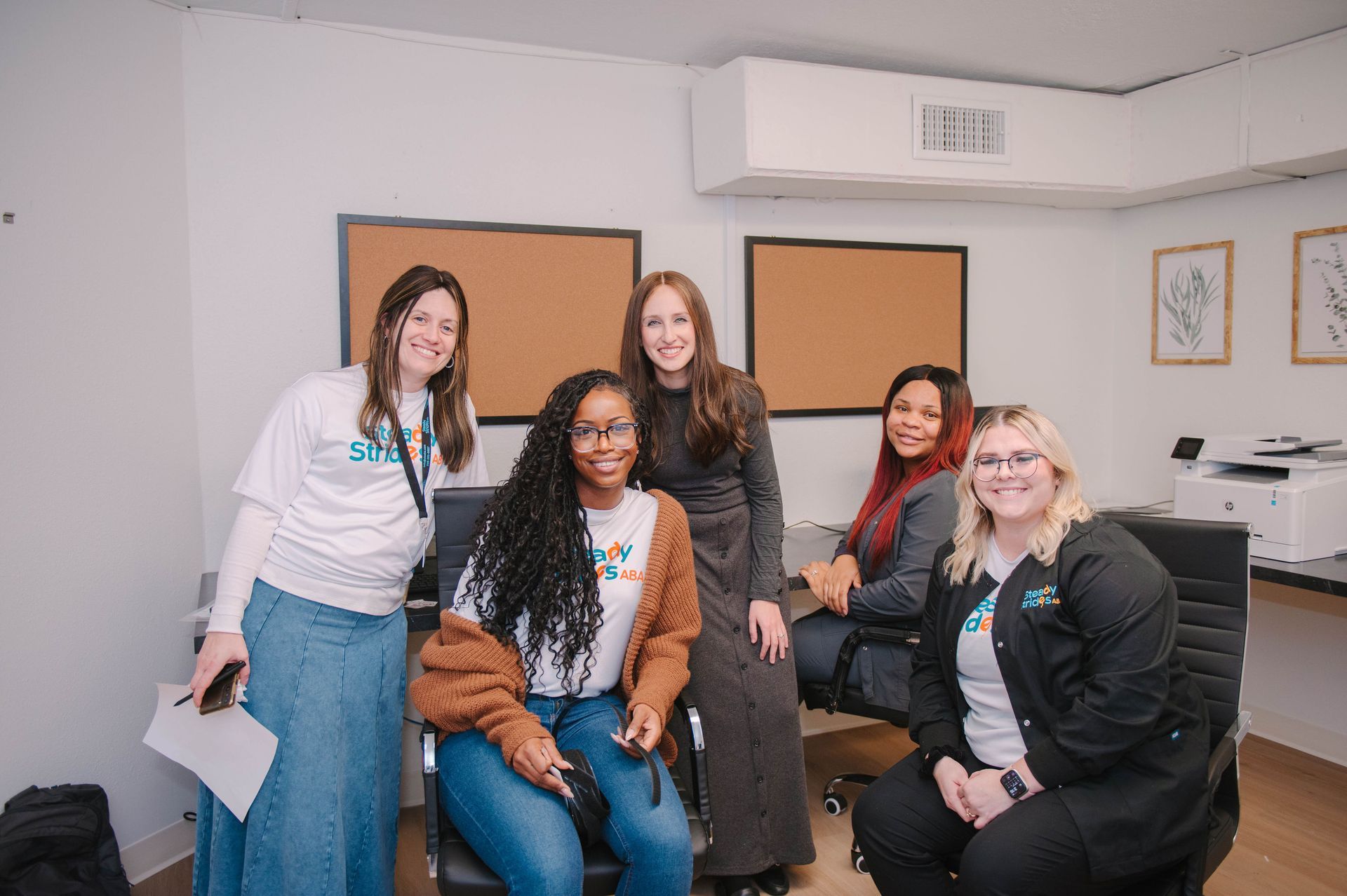 A group of women are posing for a picture in an office.