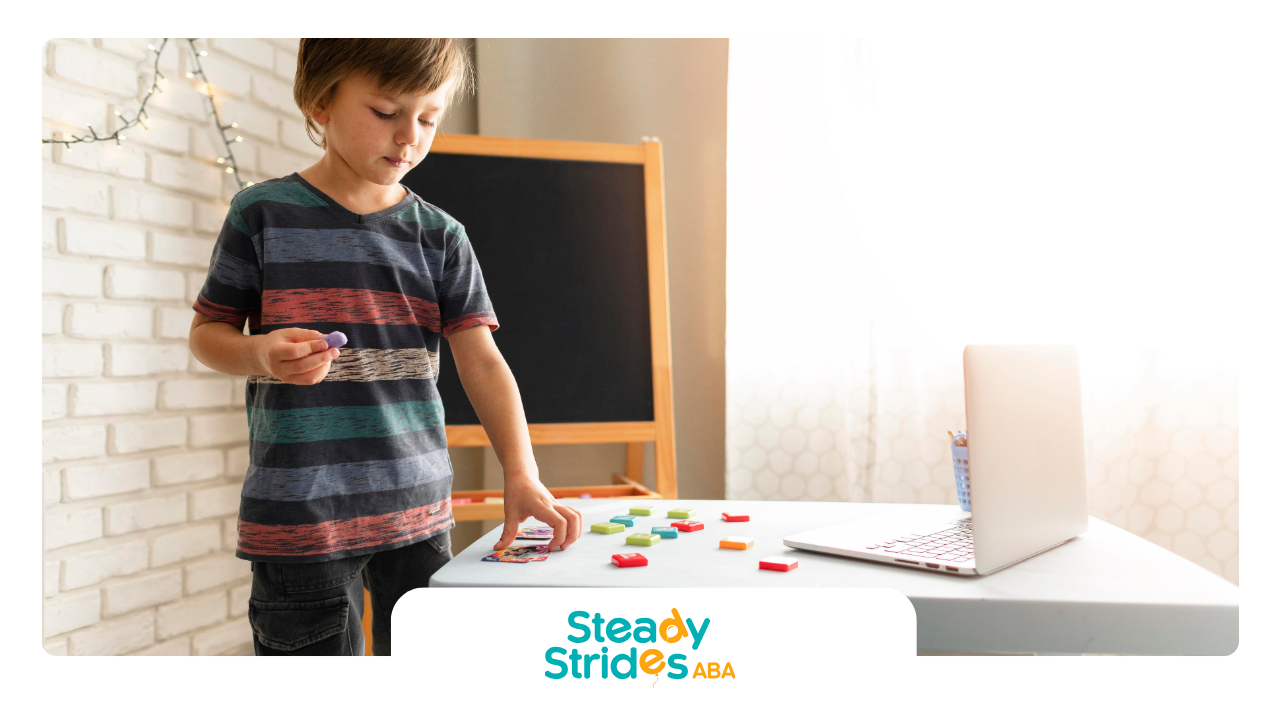 Boy with magnetic letters, looking at laptop, studying.