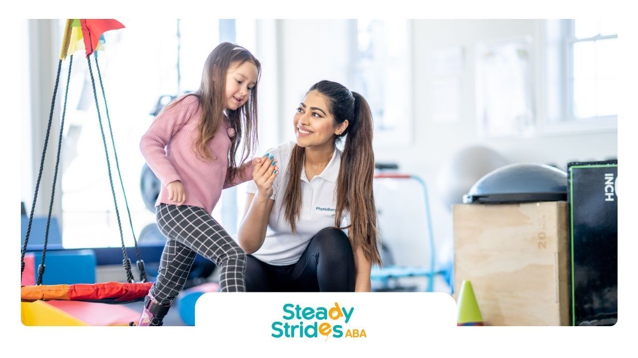 A woman is sitting next to a little girl in a gym.