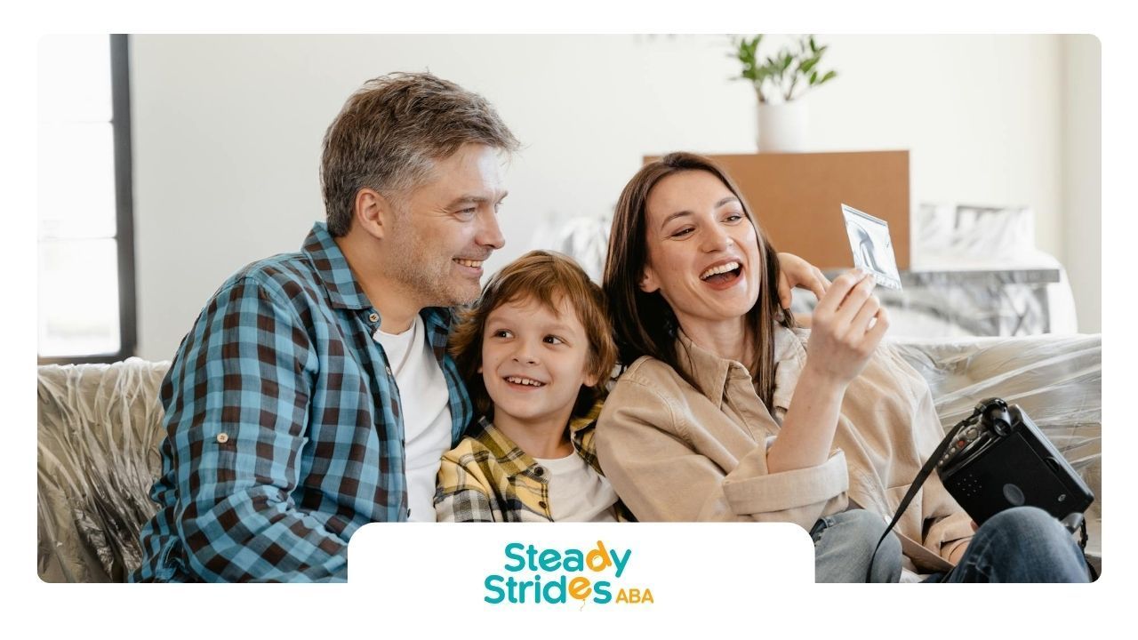 A happy family with autistic child sitting on a couch, looking at a printed ultrasound photo in TX.