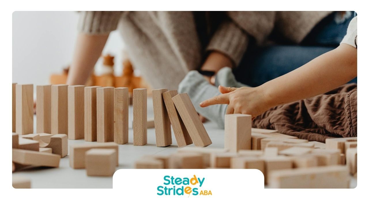 An autistic child playing with wooden blocks on the floor during in-home ABA therapy in Texas.