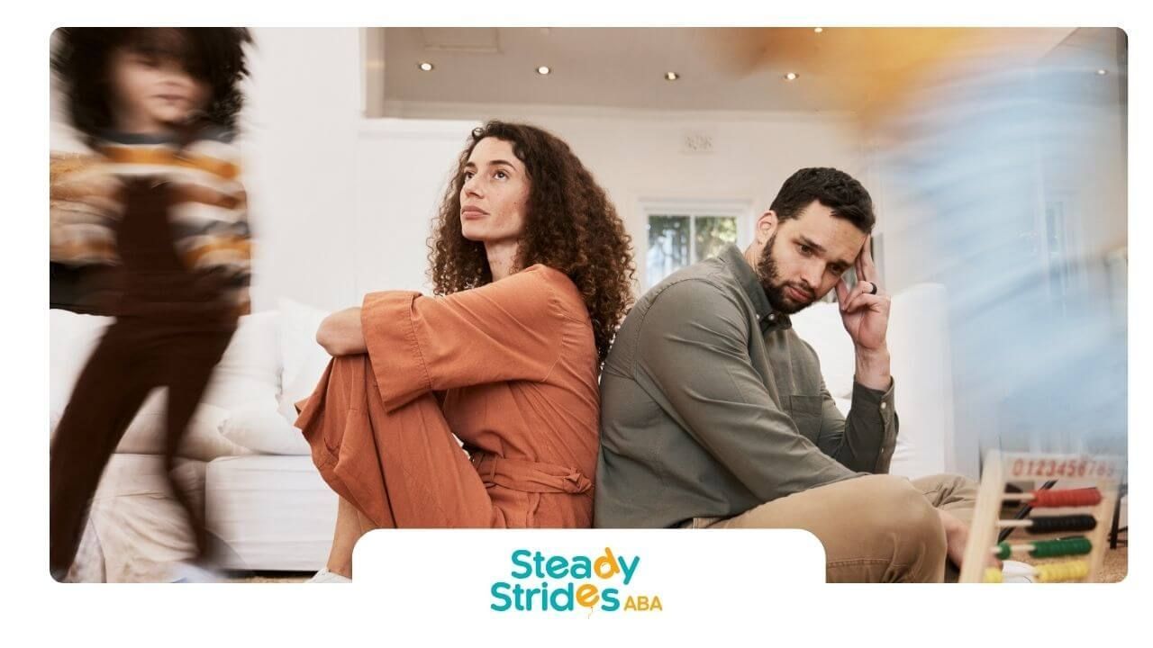 Therapist sit back to back looking stressed while their child runs past, showing emotional faces.