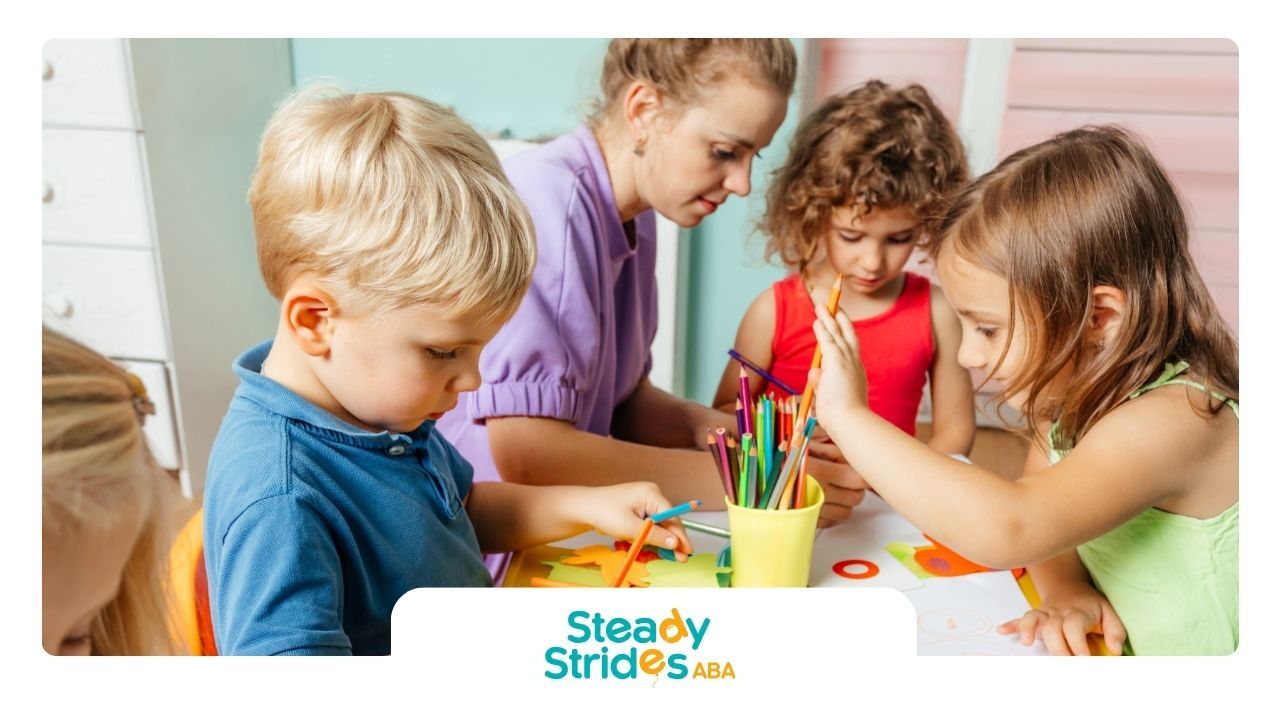 A group of children are sitting around a table with a teacher.