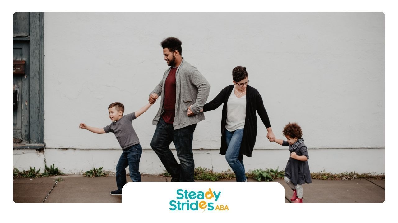 A family is walking down the street holding hands.
