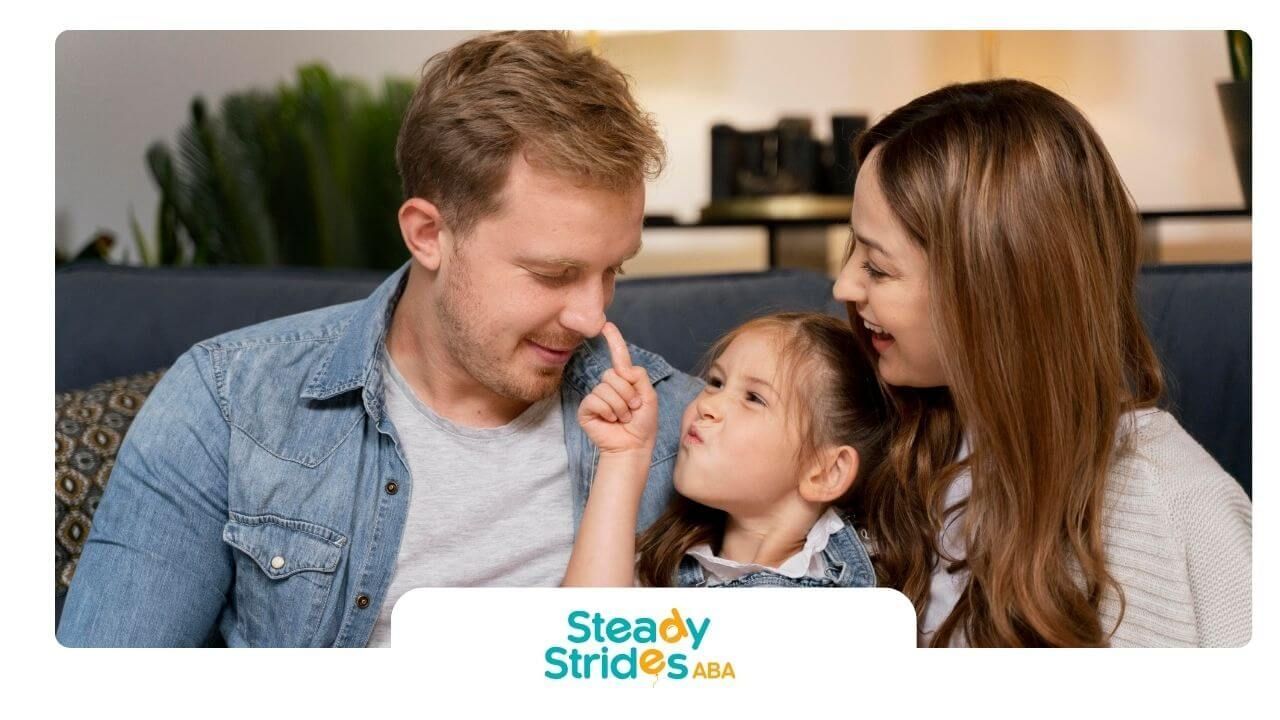 Happy family sitting on couch as young autistic daughter playfully touches her father's face