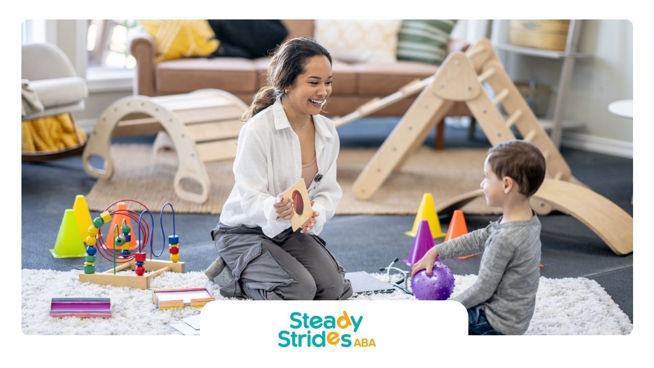 Woman interacting with a child on the floor, playing with toys; indoor setting.
