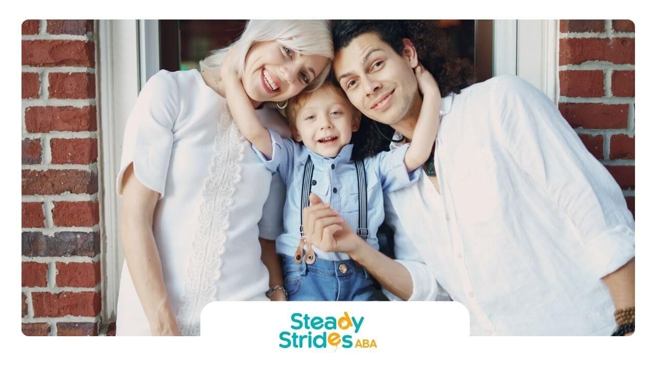 A family is posing for a picture in front of an ABA therapy center.